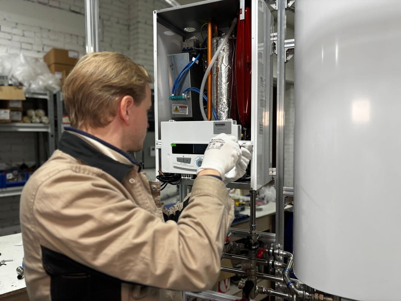 Technician servicing a modern heating system and its controls